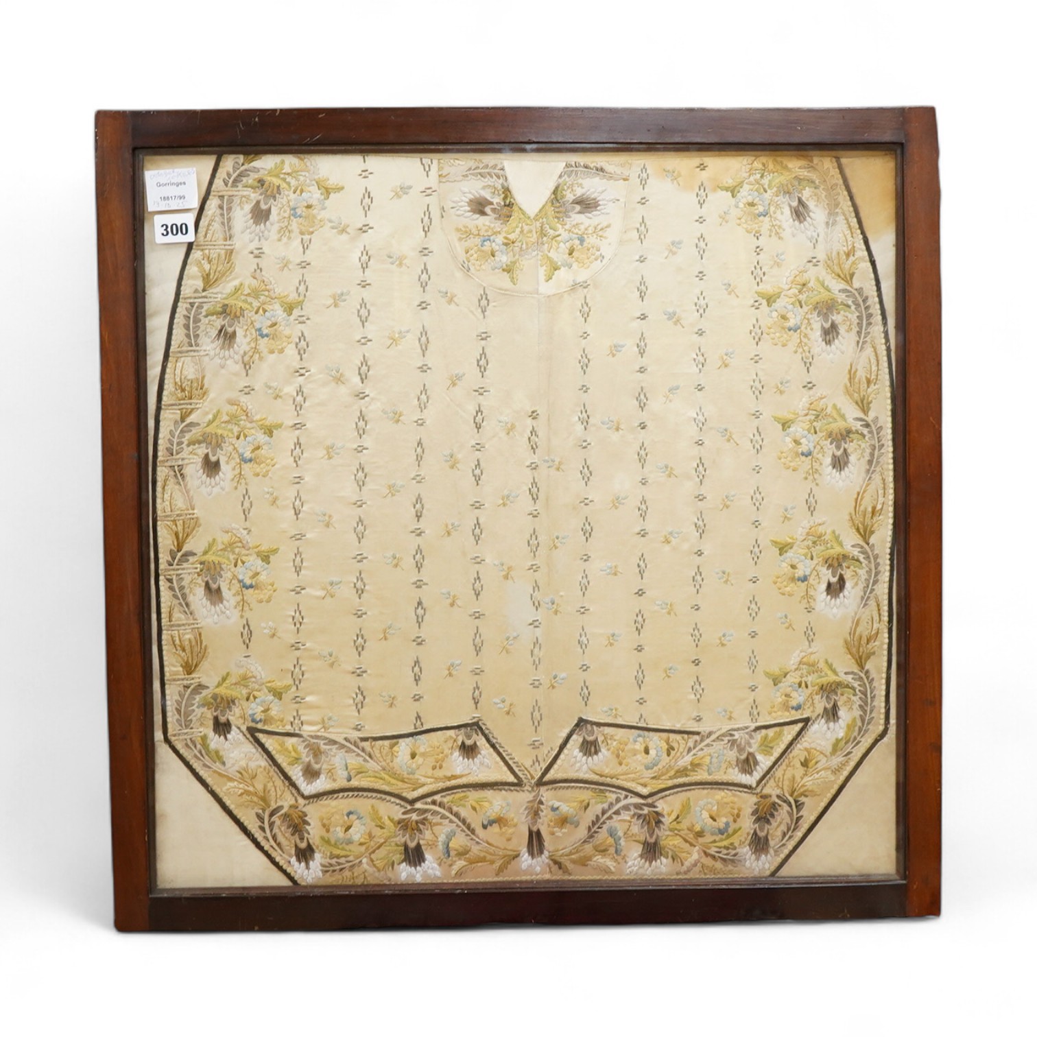 A framed front panel of a Regency silk embroidered waistcoat, ornately worked in fine polychrome silks with vining stems of leaves and hanging flowers framing a small spot motif interior, 60cm x 59cm. Condition - the sil